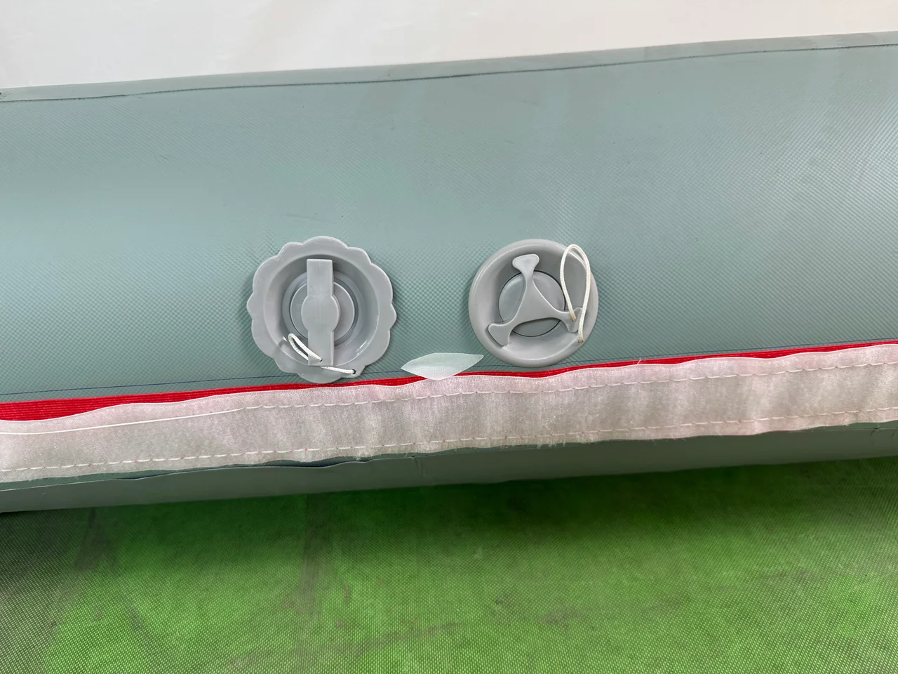 Two service valves fitted to an inflatable tent air beam beside the cover attachment edge