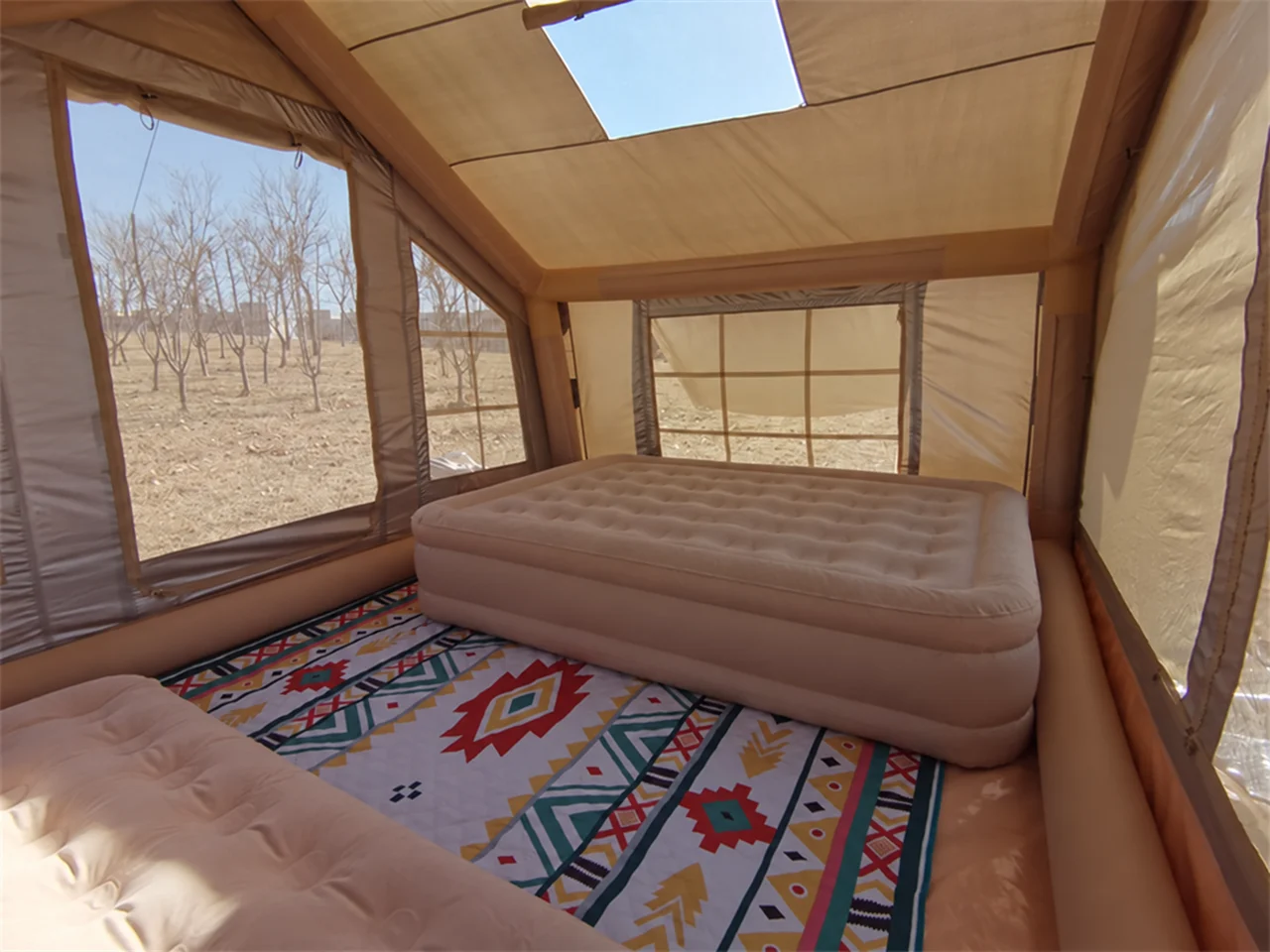 Interior of an inflatable camping tent showing the air-beam frame, windows and usable sleeping space