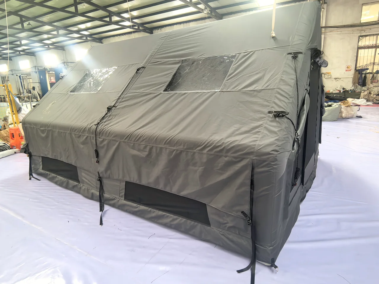 Grey LT-12 inflatable cabin tent viewed from the long side inside the workshop